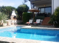 pool area equipped with sun loungers, parasol and barbecue