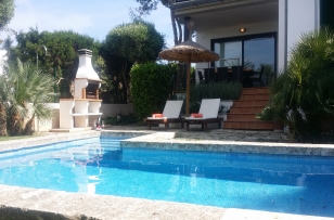 pool area equipped with sun loungers, parasol and barbecue